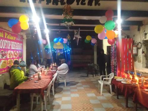 a group of people sitting at tables in a room with balloons at Hotel Sai Palace Walking Distance From Taj Mahal--View of Taj Mahal in Agra