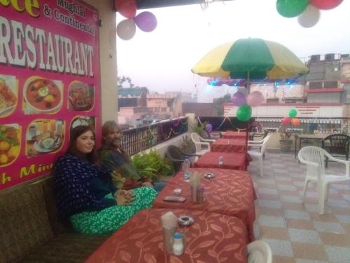 two people sitting at tables in a restaurant at Sai Palace in Agra