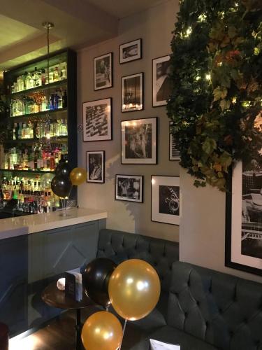 a bar with a couch and a shelf with bottles at Eurobar & Hotel in Oxford