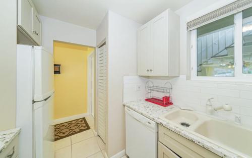 Una cocina blanca con fregadero y ventana. en King Bed - Walk to St. Armand's Circle and Lido Beach in Minutes!, en Sarasota