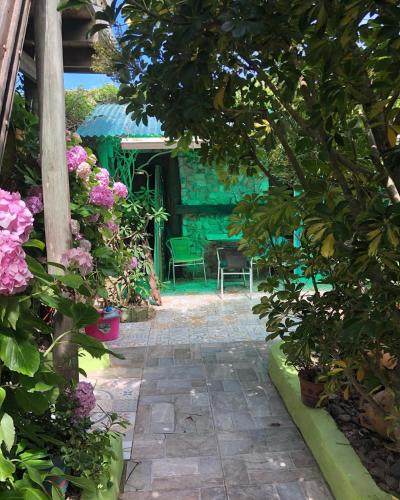 a garden with a patio with flowers and a table at El cuento del gainford in Aguas Dulces