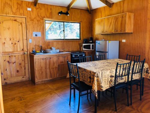 a kitchen with a table with chairs and a refrigerator at Rangi Moana in Hanga Roa