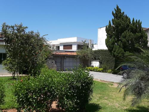 a house with a yard with trees and a driveway at Pousada Santa Fé in Aparecida