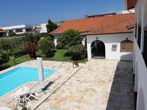 a villa with a swimming pool and a house at Pousada Santa Fé in Aparecida