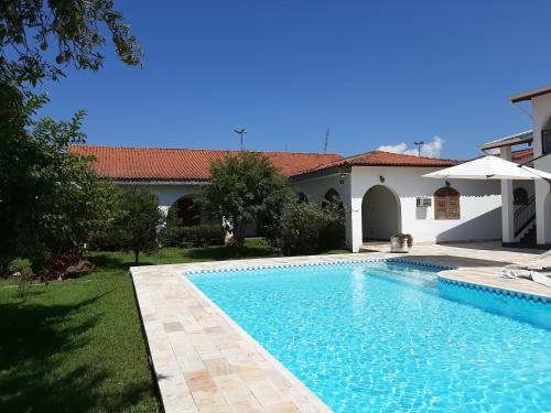 a swimming pool in front of a house at Pousada Santa Fé in Aparecida