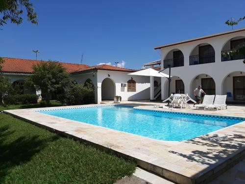 a swimming pool in front of a house at Pousada Santa Fé in Aparecida