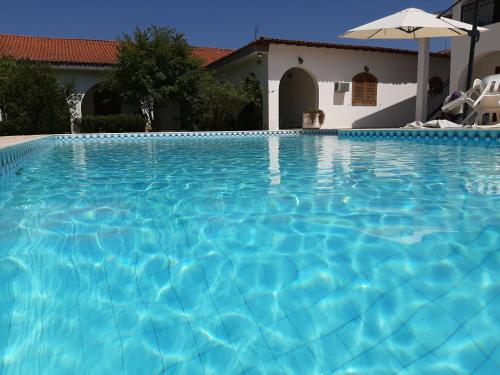 a swimming pool in front of a house at Pousada Santa Fé in Aparecida