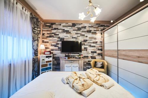 une chambre avec un lit et une télévision sur un mur de briques dans l'établissement Apartment AlPreMira, à Varna