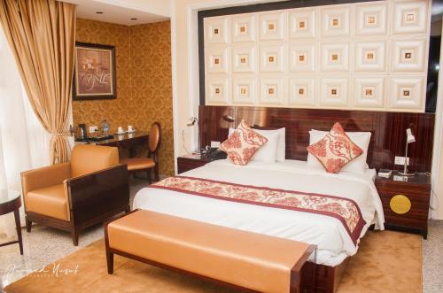 a bedroom with a bed and a desk and a chair at Conference Hotel , Abeokuta in Abeokuta