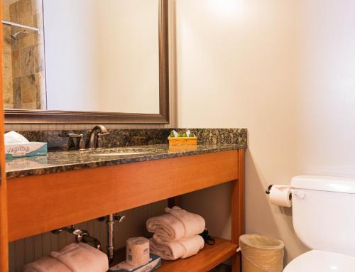 a bathroom with a sink and a pile of towels at The Black Bear Lodge at Stratton Mountain Resort in Stratton Mountain