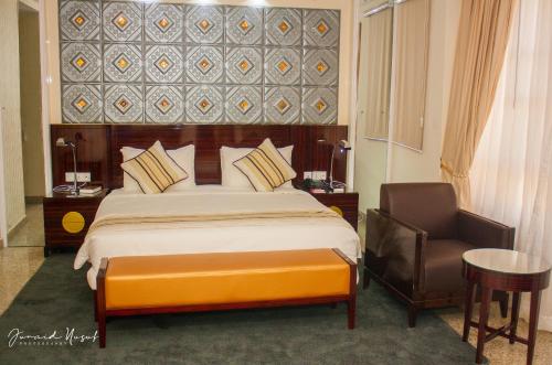 a hotel room with a bed and a chair at Conference Hotel , Abeokuta in Abeokuta