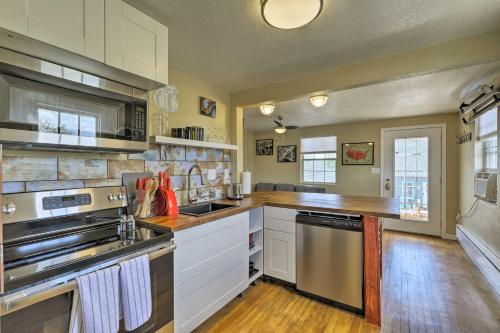 a kitchen with white cabinets and stainless steel appliances at Winslow Apartment with Jacuzzi, Deck and Grill Access! in Winslow