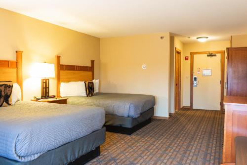 a hotel room with two beds and a hallway at The Black Bear Lodge at Stratton Mountain Resort in Stratton Mountain