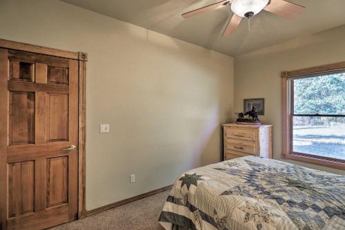 a bedroom with a ceiling fan and a bed and a window at Kalispell Riverfront Home by Glacier National Park in Kalispell