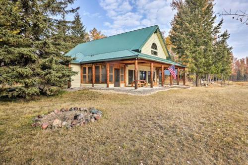 a house with a green roof in a field at Kalispell Riverfront Home by Glacier National Park in Kalispell