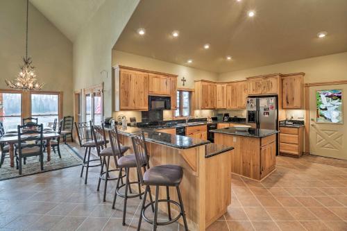 a large kitchen with wooden cabinets and a table with chairs at Kalispell Riverfront Home by Glacier National Park in Kalispell