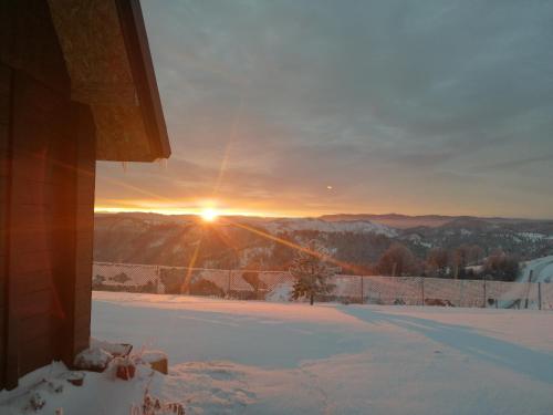 a view of the sunset from a house in the snow at Vikendica RANKOVIĆI in Mokra Gora