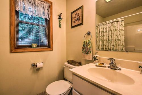 Un baño con lavabo, inodoro y espejo. en Pocono Mountain Home with 3 Community Lakes!, en Gouldsboro