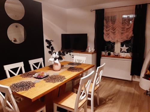 a dining room with a wooden table with white chairs at Willa Ale Góry Dom na wyłączność , Beskid Żywiecki in Korbielów