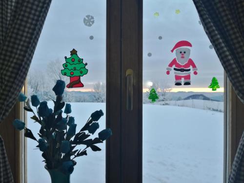 a window with christmas decorations in a room at Vikendica RANKOVIĆI in Mokra Gora