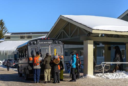 a group of people standing at a bus stop at The Black Bear Lodge at Stratton Mountain Resort in Stratton Mountain