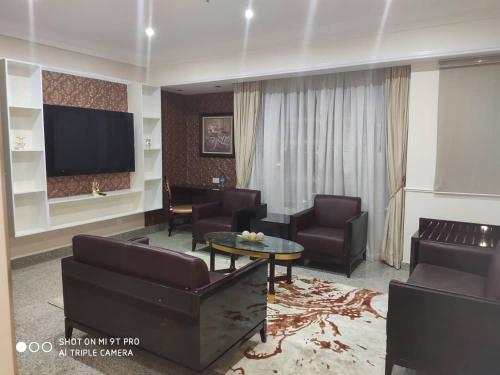 a living room with couches and a flat screen tv at Conference Hotel , Abeokuta in Abeokuta