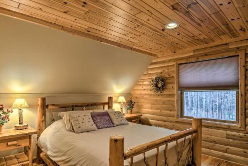 ein Schlafzimmer in einem Blockhaus mit einem Bett und einem Fenster in der Unterkunft Camp Tony with Trail Access Walk to Lake Huron! in High Banks