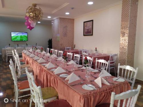 a long table in a room with white chairs at Conference Hotel , Abeokuta in Abeokuta