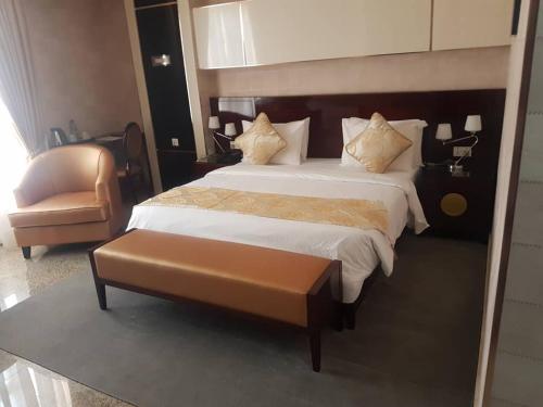 a bedroom with a large bed and a chair at Conference Hotel , Abeokuta in Abeokuta