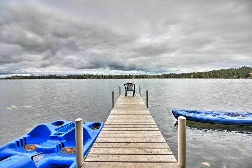 a dock with two blue boats on a lake at Loon Lake Lodge with Dock, Sauna and Hot Tub! in Pequot Lakes
