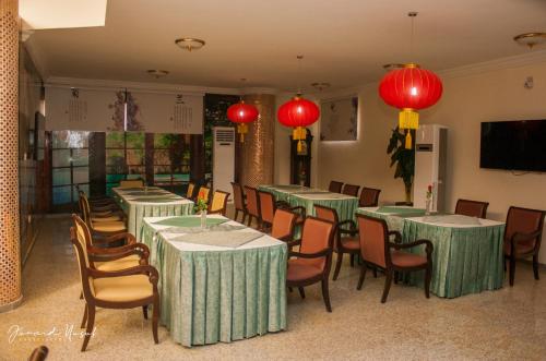 a dining room with tables and chairs and red lanterns at Conference Hotel , Abeokuta in Abeokuta