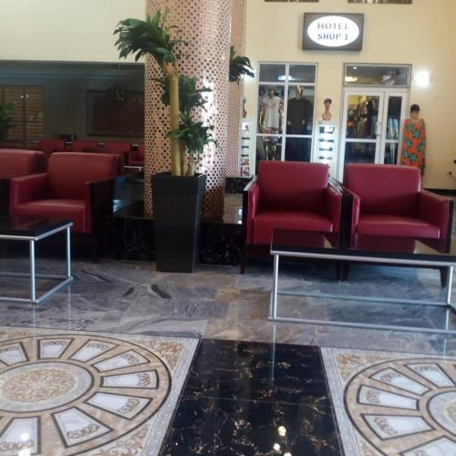 a waiting room with red chairs and a table at Conference Hotel , Abeokuta in Abeokuta