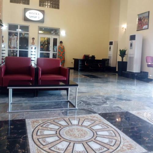 a lobby with two red chairs and a table at Conference Hotel , Abeokuta in Abeokuta