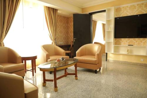 a living room with chairs and a table and a tv at Conference Hotel , Abeokuta in Abeokuta