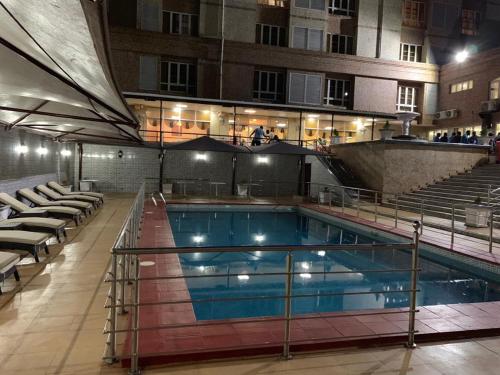 a large swimming pool in a building with chairs at Conference Hotel , Abeokuta in Abeokuta