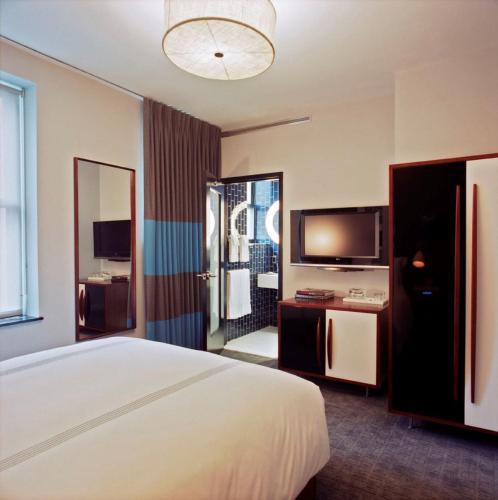 a hotel room with a bed and a television at 6 Columbus Central Park Hotel in New York