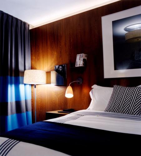 a bedroom with a bed and a lamp and a picture at 6 Columbus Central Park Hotel in New York