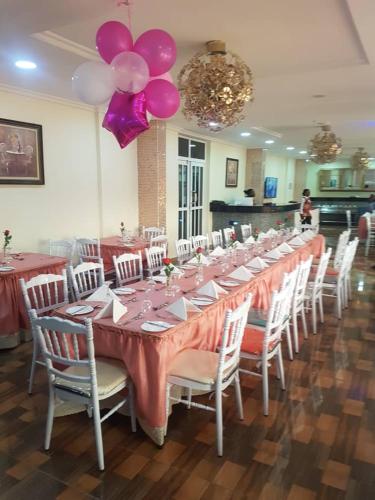 a long table with pink tables and chairs with balloons at Conference Hotel , Abeokuta in Abeokuta