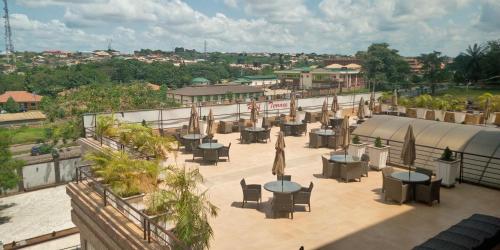 a patio with tables and umbrellas on top of a building at Conference Hotel , Abeokuta in Abeokuta