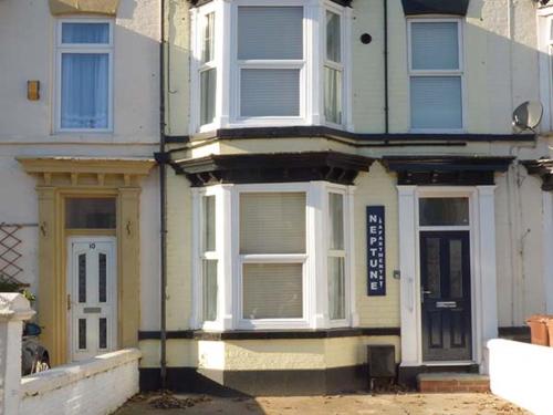a white house with white windows and a door at Flat 1 in Bridlington