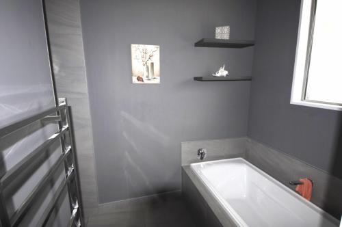 uma banheira branca na casa de banho com uma janela em Deb's Place em Swannanoa