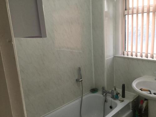 a bathroom with a bath tub and a sink at Holiday / vacation Double Room in Greater manchester in Summerseat