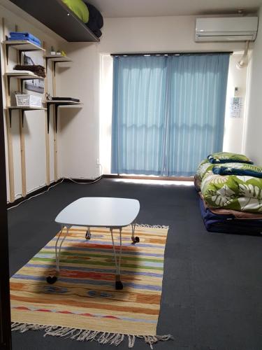 sala de estar con mesa y sofá en Nomad Apartment Stay, en Kumamoto