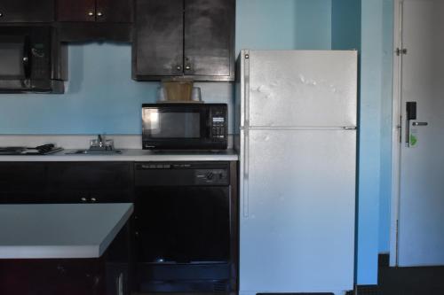 a kitchen with a refrigerator, microwave and sink at Guest Cottages & Suites in Brunswick
