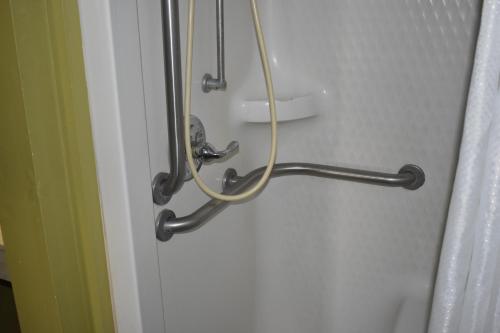 a white wire hanging from a wall above a shower door at Guest Cottages & Suites in Brunswick