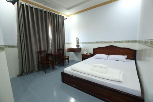 a bedroom with a large bed and a bathroom at Tina 2 Hotel in Cái Răng