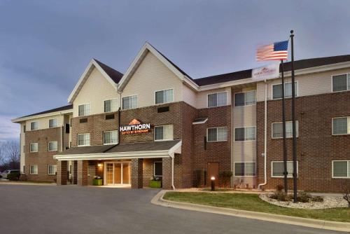 a hotel with an american flag in front of it at Hawthorn Extended Stay by Wyndham Milwaukee Airport in Milwaukee
