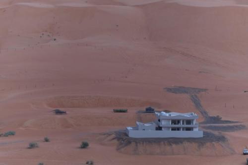a white building in the middle of a desert at Home X4 in Al Wāşil