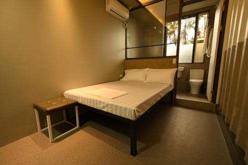 Dormitorio pequeño con cama y aseo en Hotel Snow Angeles en Ángeles