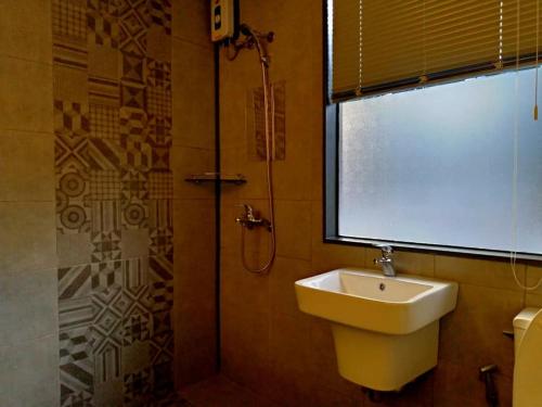 een badkamer met een wastafel, een douche en een raam bij Hotel Snow Angeles in Angeles